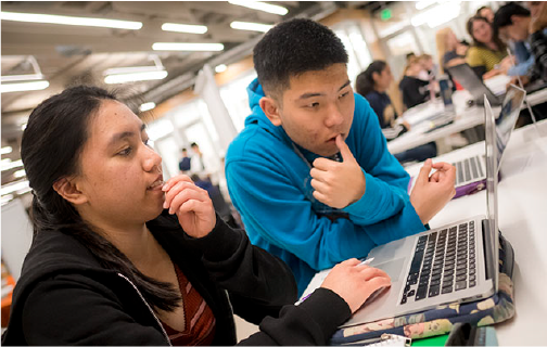 two learners at a laptop