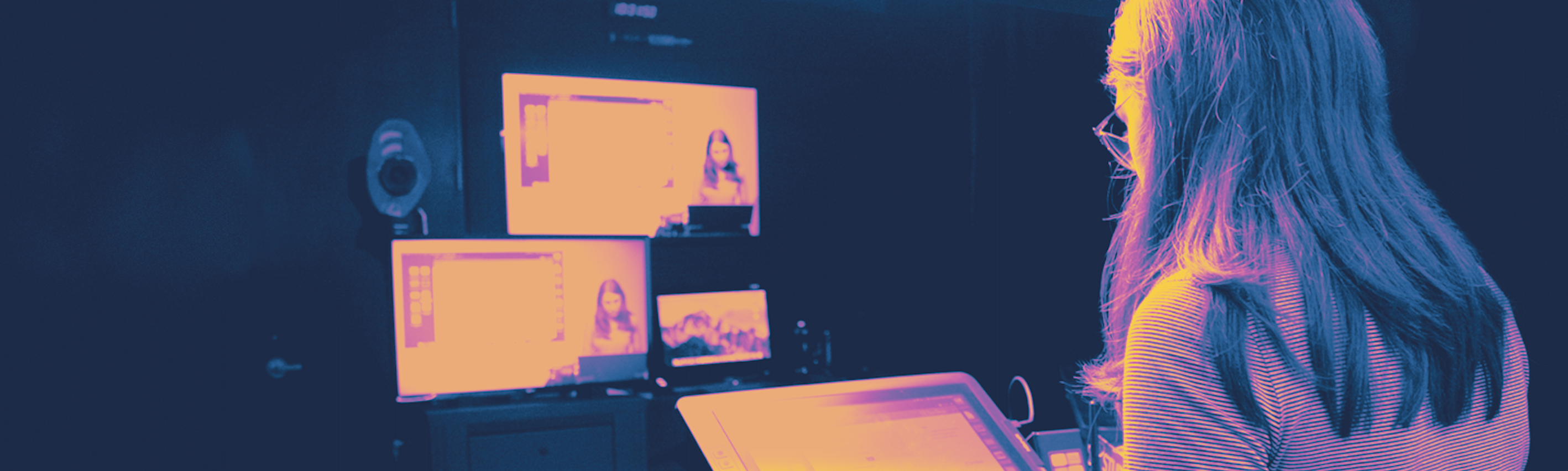 A woman is looking at several screens.